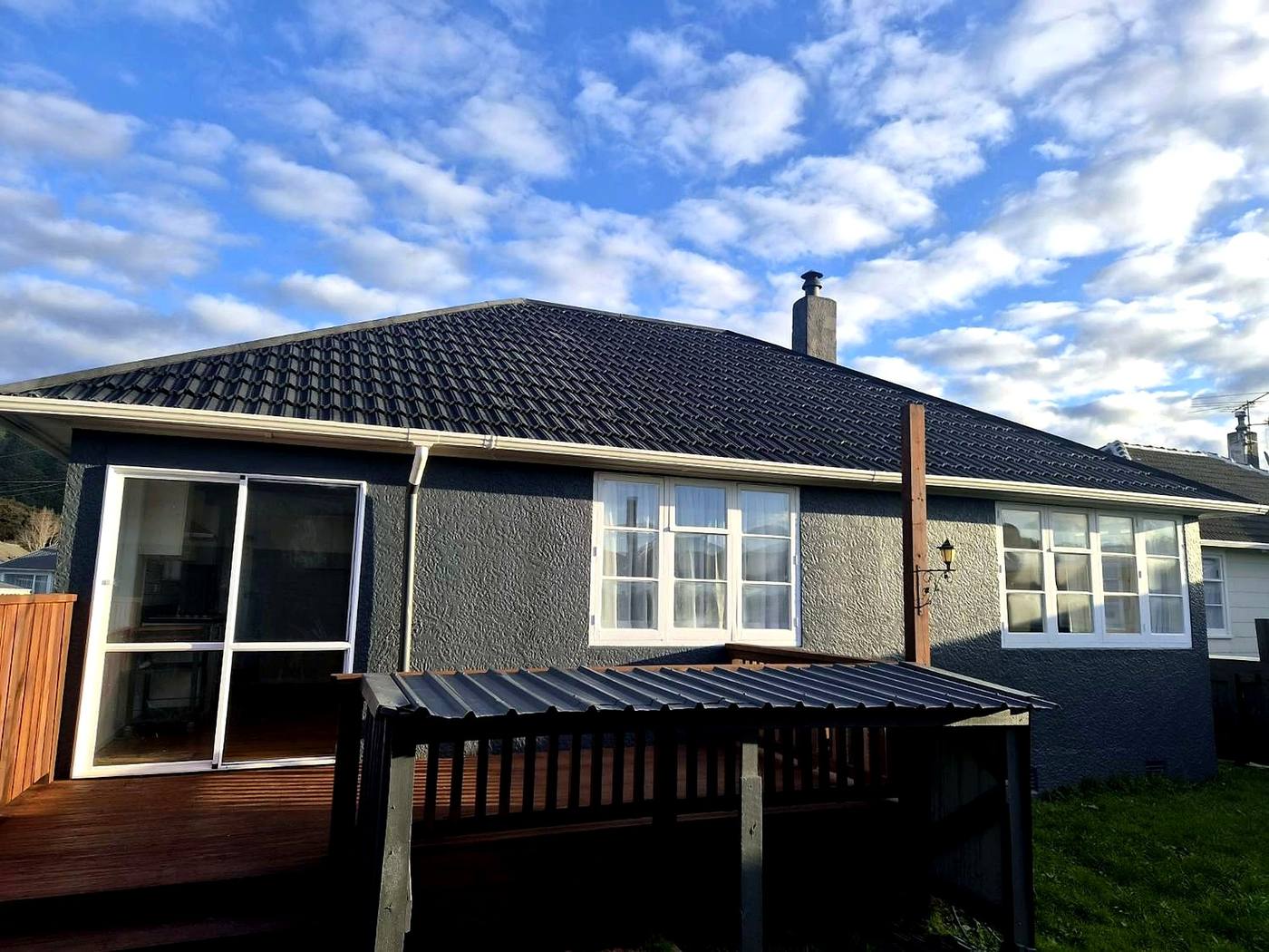 Cream bungalow with a recoted dark tile roof seen from the garden