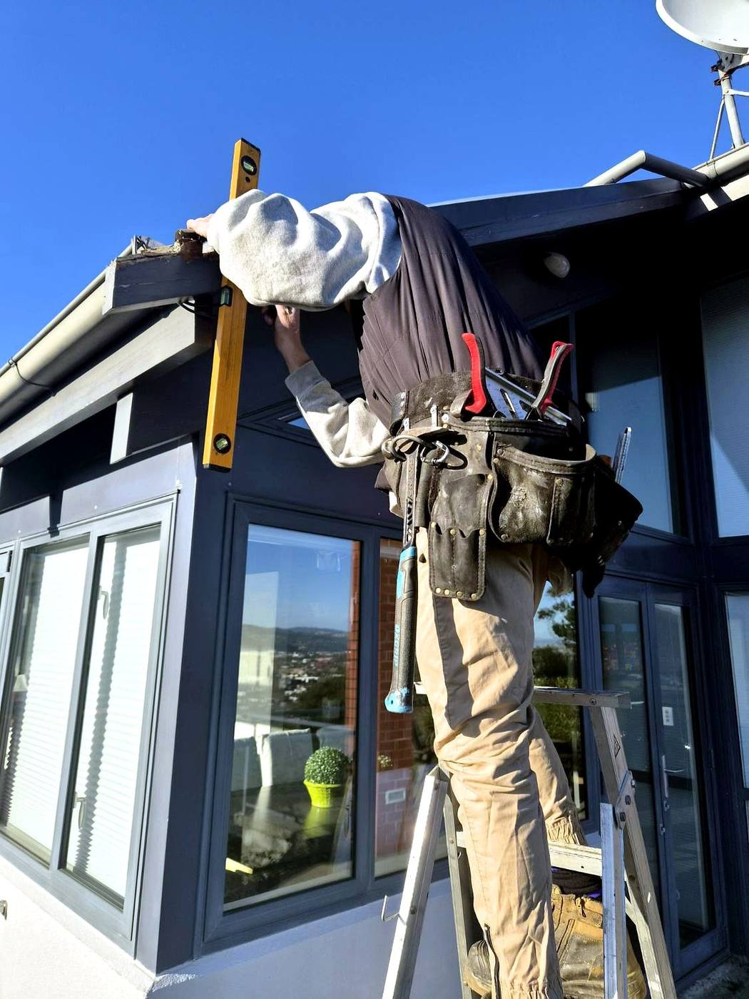 Spirit level checking a new fascia board