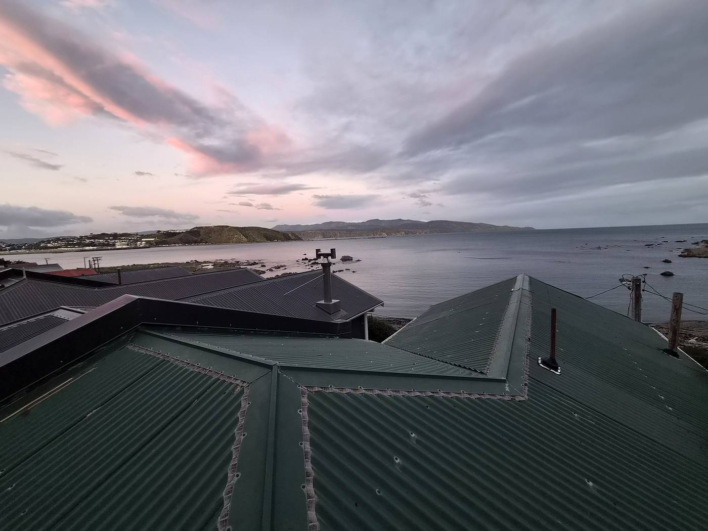 Green corrugated iron roof over the harbour at sunset
